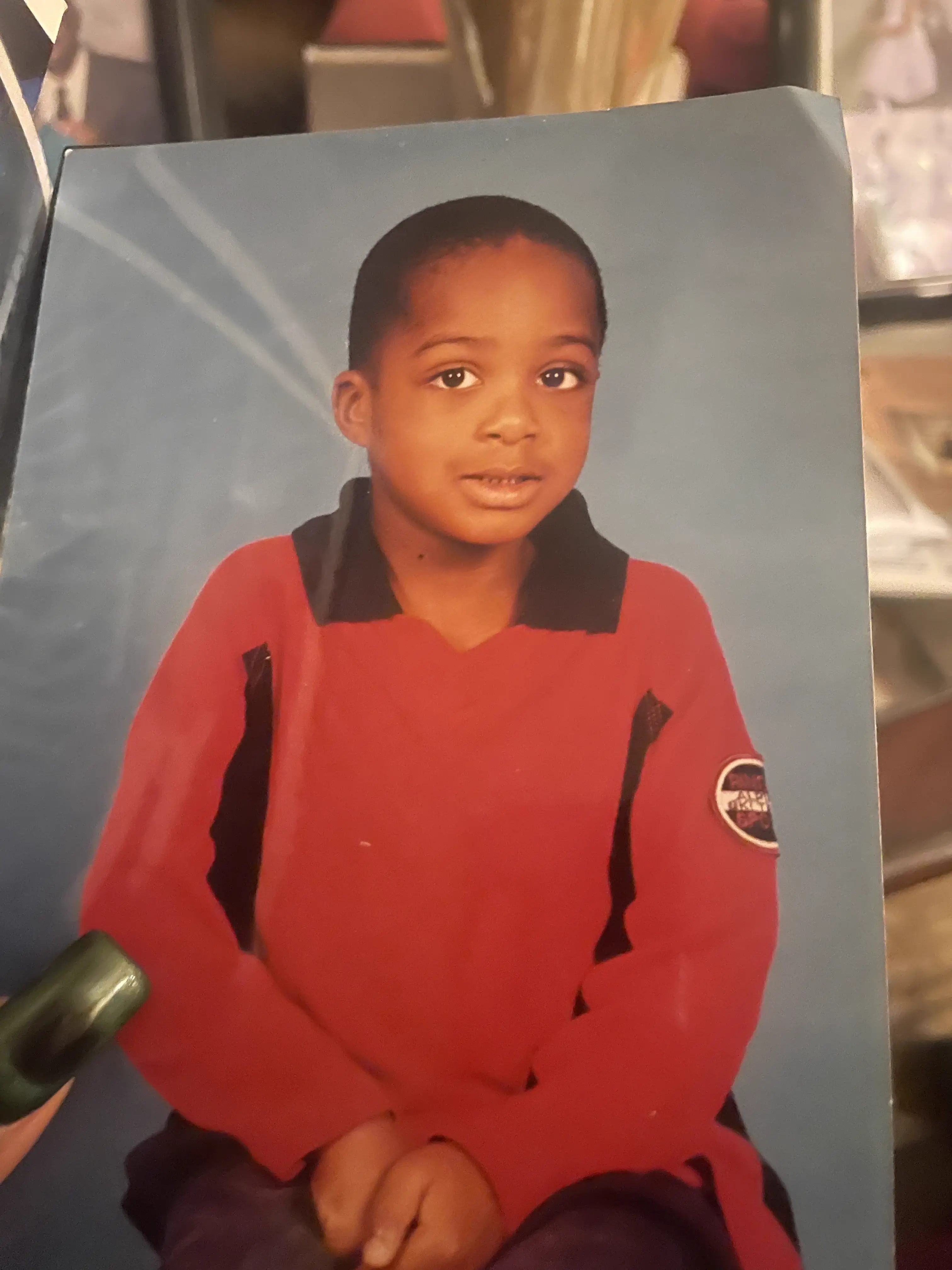 Input portrait of a child wearing a red shirt against a blue studio background